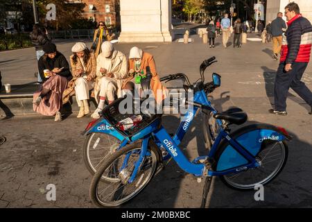 Abgelenkte Besucher des Washington Square Park in Greenwich Village in New York entspannen sich am Donnerstag, den 24. November 2022. (© Richard B. Levine) Stockfoto