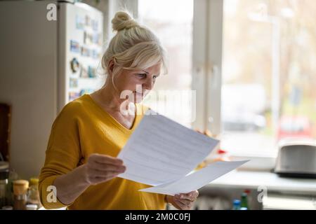 Seniorin, die Finanzberichte ausfüllt Stockfoto