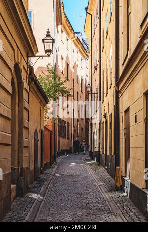 STOCKHOLM, SCHWEDEN - 31. JULI 2022: Eine der vielen alten Kopfsteinpflasterstraßen in der Gamla Stan Gegend. Stockfoto