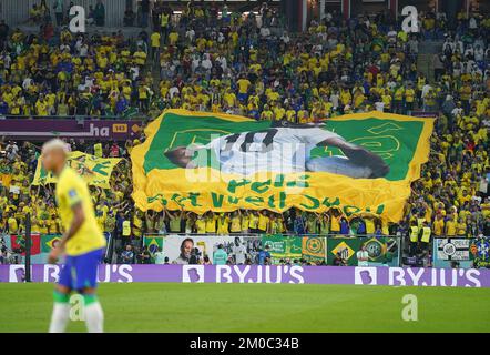 Brasilianische Fans auf den Tribünen halten ein Banner und wünschen sich, dass der ehemalige Spieler Pele während der FIFA-Weltmeisterschaft mit 16 Spielen im Stadium 974 in Doha, Katar, bald gesund wird. Foto: Montag, 5. Dezember 2022. Stockfoto