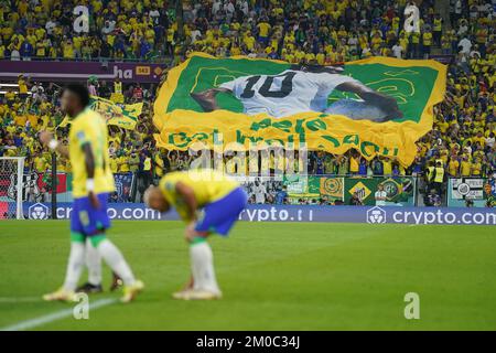 Brasilianische Fans auf den Tribünen halten ein Banner und wünschen sich, dass der ehemalige Spieler Pele während der FIFA-Weltmeisterschaft mit 16 Spielen im Stadium 974 in Doha, Katar, bald gesund wird. Foto: Montag, 5. Dezember 2022. Stockfoto