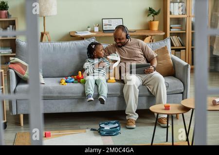 Porträt eines alleinerziehenden, glücklichen Vaters, der mit dem kleinen Sohn spielt, während er von zu Hause aus arbeitet, Kopierbereich Stockfoto