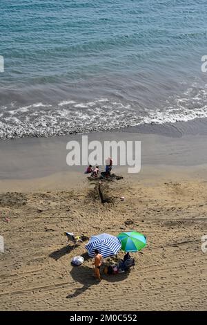 Playa El Veril Strand mit Sonnenanbetern auf Sand andere im Meer, San Agustín, Las Palmas, Gran Canaria Stockfoto