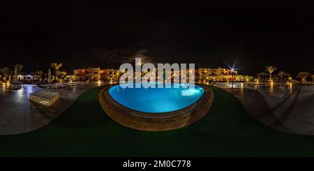 360 Grad Panorama Ansicht von DAHAB, ÄGYPTEN - 2021. DEZEMBER: Nahtlose, kugelförmige Nacht 360 Panorama in der Nähe des beleuchteten Pools auf dem Gebiet eines Elite-Hotels in der Wüste am Ufer von Rot