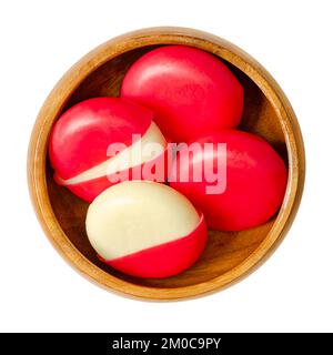 Imbiss-Käsescheiben in roten Wachsgehäusen, in einer Holzschüssel. Kleine edamer-Scheiben, jeweils mit einer Mischung aus rotem Paraffin umhüllt. Stockfoto