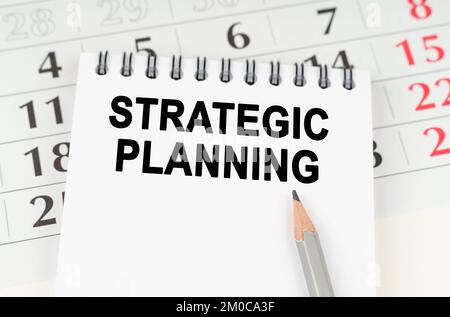 Geschäftsplanungskonzept. Auf dem Kalender steht ein Notizbuch mit der Aufschrift "strategische Planung" Stockfoto