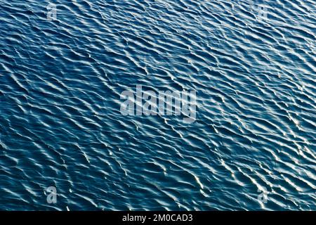 Hellblauer Farbverlauf abstrakter Hintergrund der welligen Meeresoberfläche Stockfoto