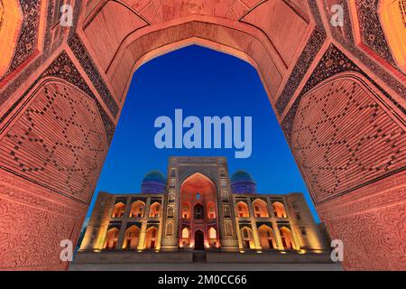 Blick über die POI Kalon Madrassa durch den Bogen, in der Dämmerung, Bukhara, Usbekistan. Stockfoto