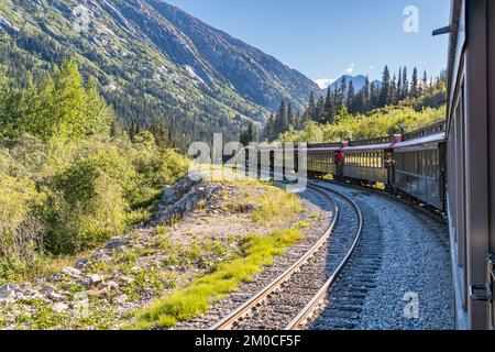 Skagway, AK - 7. September 2022: Der White Pass und Yukon Route Zug schlängelt sich durch die Berge östlich von Skagway. Stockfoto