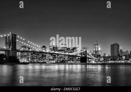 Schwarzweißbild der Brooklyn Bridge und Manhattan von Dumbo bei Nacht, New York City, USA Stockfoto