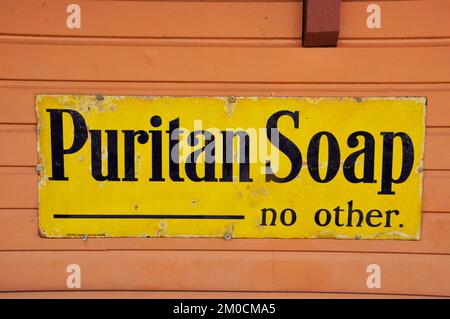 Emailliertes Metallschild, Werbung Puritan Soap fotografiert am Bishops Lydeard Bahnhof an der West Somerset Eisenbahn in Somerset, England, Großbritannien Stockfoto