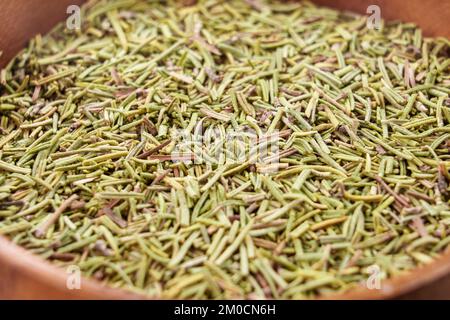Trockener Kräuter-Rosmarin-Gewürz in einer Holzschüssel. Getrocknete, nach Duft geschnittene Kräuter. Makro Stockfoto