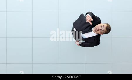 Erfolge feiern. Low-Angle-Blick auf einen aufgeregten jungen Geschäftsmann, der die Arme hält Stockfoto