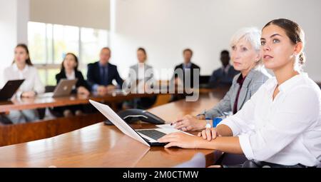Eine weiße, braune Geschäftsfrau der Jahrtausendwende, die an der Präsentation teilnimmt Stockfoto