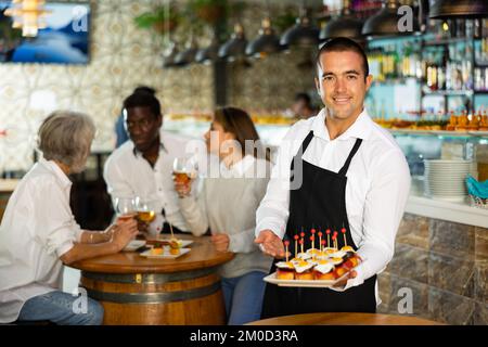 Blick auf den jungen Latino-Mann mit Pinchos Stockfoto