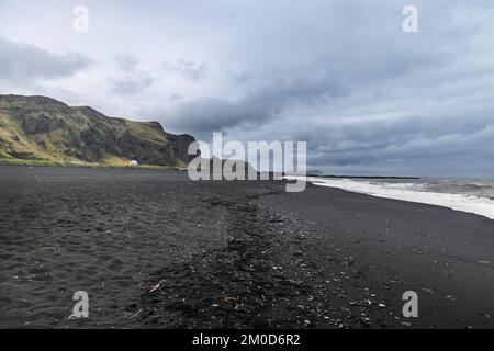 Der malerische vulkanische schwarze Sandstrand von Vik in Island ist ein beliebtes und berühmtes Touristenziel Stockfoto