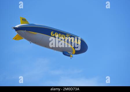 IRVINE, KALIFORNIEN - 27. NOVEMBER 2022: Die Goodyear Airship Wingfoot Three von unten gesehen gegen einen hellblauen Himmel mit Wolken. Stockfoto