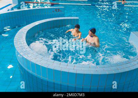 Verschiedene Schwimmbäder im Pool Park. Ein paar weiße Rentner oder Großeltern verbringen ihre Freizeit aktiv im Lazy River und Whirlpool. Hochwertiges Foto Stockfoto