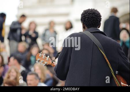 PARIS, FRANKREICH - 15. MAI: Männlicher Musiker spielt am 15. Mai 2009 in Paris, Frankreich, auf der Straße bei Sacre Coeur um Geld. Auf den Stufen von Sacré Stockfoto