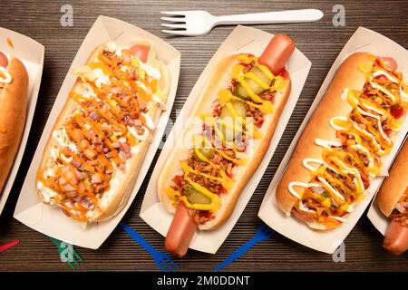 Eine Reihe köstlicher Hot Dogs aus verschiedenen Rezepten in Papiergondeln Stockfoto