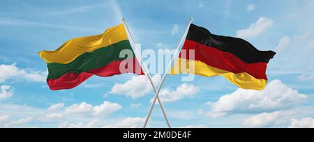 Zwei überkreuzte Flaggen Bundesrepublik Deutschland und Litauen winken im Wind am bewölkten Himmel. Beziehungskonzept, Dialog, Reisen zwischen zwei Paaren Stockfoto