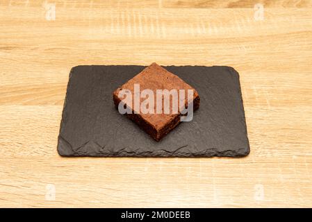 Ein Brownie ist ein kleiner Schokoladenkuchen, typisch für die Gastronomie der Vereinigten Staaten. Er ist nach seiner dunkelbraunen Farbe benannt, oder in Englisch braun Stockfoto