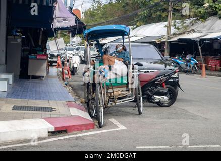 SAMUT PRAKAN, THAILAND, NOVEMBER 23 2022, Ein müder Dreiradfahrer, der auf dem Sitz schläft Stockfoto