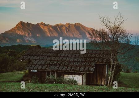 Alte Holzhütte in den wunderschönen Bergen im Winter auf dem Land. Altes Haus gegen fantastische Aussicht auf die Berge an sonnigen Tagen. Stockfoto