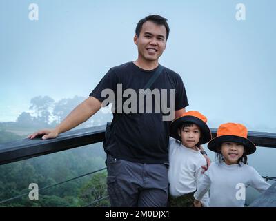 Glücklicher Vater und glückliche Tochter, die zusammen Fotos in den Bergen an einem wunderschönen Wintermorgen machen. Eine Familie auf einer Wanderung durch den Wald. Stockfoto