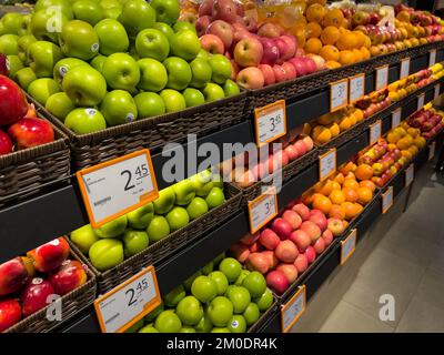 Diagonalwinkel von frischem Obst wie Äpfeln und Orangen in den Regalen, damit Verbraucher es im Supermarkt kaufen können. Stockfoto