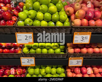 Frische rote Äpfel und grüne Äpfel stehen auf Regalen, die die Verbraucher im Supermarkt kaufen können. Stockfoto