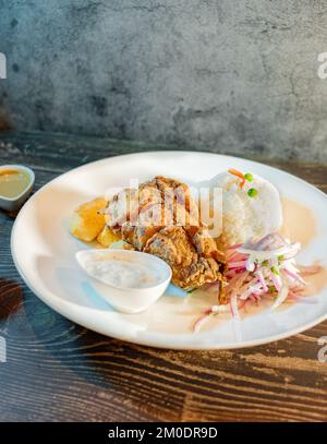 Gebratenes Fischfilet mit weißem Reis, Kartoffeln und Salat Stockfoto