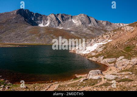 Ein Pfad am Ufer des Summit Lake am Mount Evans, Colorado, unter dem Sommerhimmel. Stockfoto