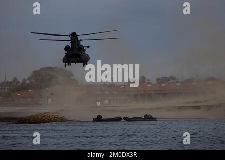 EIN US-AMERIKANISCHER Army MH-47 Chinook Hubschrauber mit 160. Special Operations Aviation Regiment landet in der Nähe des Del Mar Boat Basin während des Helocast Trainings mit den USA Marines von Bravo Company, 1.. Aufklärungsbataillon, 1.. Marine Division, als Teil von Steel Knight 23 im Marine Corps Base Camp Pendleton, Kalifornien, 2. Dezember 2022. Steel Knight ist eine jährlich stattfindende kombinierte Feuerübung, die sicherstellt, dass 1. MARDIV für die Expeditionskampfführung der Marine in umkämpften Räumen optimiert und speziell für künftige Operationen an Land und über Wasser gebaut ist. (USA Marinekorps (Foto: CPL. Willow Marshall) Stockfoto