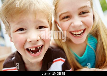 Sie waren so aufgeregt. Zwei niedliche kleine Kinder lächeln und lachen zusammen. Stockfoto