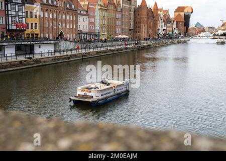 Danzig Polen Mai 2022 touristische Schifffahrt Altstadt in Danzig. Das Schiff mit Touristen fährt auf der Granary Island Reflection in Moltawa River Cityscap zu einer Kreuzfahrt am Flussufer ab. Uralter Kran. Besuchen Sie Danzig Poland Travel Destination. Touristenattraktion Stockfoto