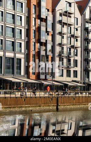 Moderne Gebäude über dem Fluss Motlawa in der Altstadt. Abstrakte Struktur. Kreatives Foto Tourismus auf dem Motlawa River. Neue Apartments-Architektur auf Granary Island Glasfenster mit Reflexionen. Touristisches Reiseziel Stockfoto