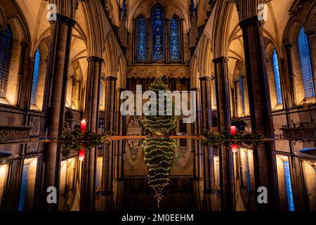 Richard Pike, der kirchliche Schreiner der Kathedrale von Salisbury, dekoriert die 32ft im Longleat Forest verbaute norwegische Fichte Weihnachten, da sie im Inneren des Kirchennetzes der Kathedrale installiert ist. Foto: Montag, 5. Dezember 2022. Stockfoto