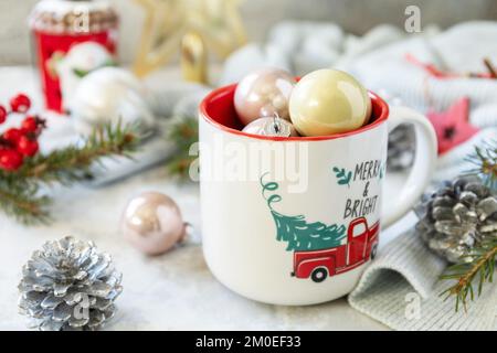Frohe Weihnachten und frohe Feiertage Grußkarte Neujahr. Weihnachtsbecher mit Weihnachtsdekoration und Pinienzweigen. Stockfoto