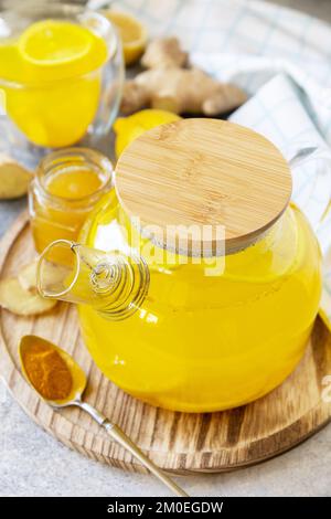 Gesundes Bio-veganes Getränk. Antioxidans Ingwer Kurkuma-Zitronentee mit Honig auf einem Steintisch. Wintertee, Immunitätsförderungsgetränk. Stockfoto