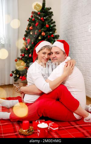 Romantisches junges Paar, das Weihnachtsgeschenke tauscht. Winterferien Stockfoto