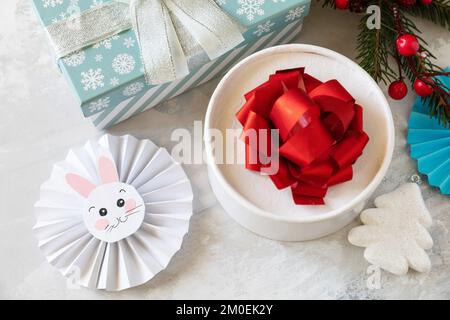 Weihnachtshintergrund mit Weihnachtsbaum, Geschenkboxen und Symbol des Jahres Mond, chinesischer Kalender, Jahr des Hasen. Wintersaison Grußkarte. Stockfoto