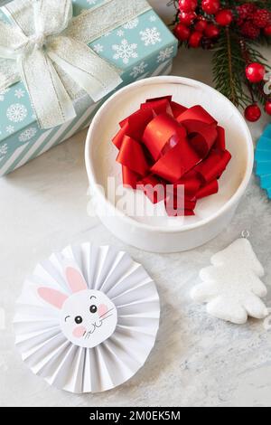 Wintergrußkarte. Weihnachtshintergrund mit Weihnachtsbaum, Geschenkboxen und Symbol des Jahres Mond, chinesischer Kalender, Jahr des Hasen. Stockfoto