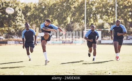 Mixed Race Rugby-Spieler, der während eines Rugby-Spiels draußen auf dem Spielfeld einen dropkick versucht. Hispanischer Mann tritt wegen Berührung oder versucht, drei Punkte zu erzielen Stockfoto