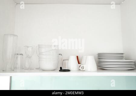 Ein Regal mit Geschirr im Küchenschrank. Stockfoto