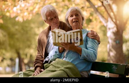 Seniorenpaar, Buch lesen und sich im Sommer auf der Bank entspannen, um die Freiheit des Ruhestands zu genießen, Reisen Abenteuer und glücklich zusammen im New York Park. Liebe Stockfoto