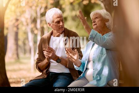 Seniorenpaar, Naturpark und Unterhaltung für Unterstützung, Kommunikation und Entspannung in der Sonne zusammen. Alter Mann, Frau und Gebärdensprache im Garten Stockfoto