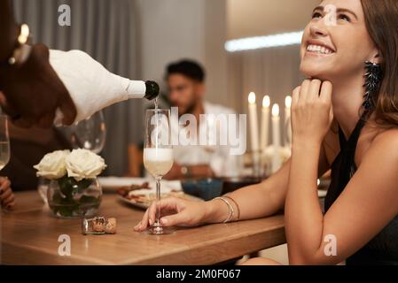 Party, Champagner und Frau bei einem Dinner mit Freunden, um Silvester zu feiern. Freundschaft, Sekt oder Alkohol zu einem Bußgeld servieren Stockfoto