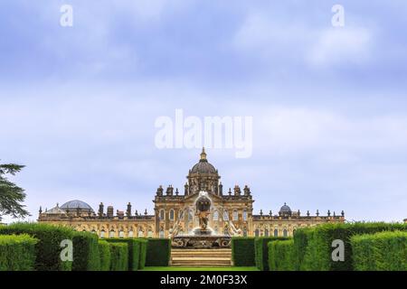 Fassade des Schlosses Howard mit Atlas-Brunnen aus den Parterre-Gärten südlich des Palastes, Großbritannien. Stockfoto