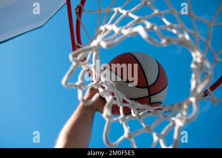 Hände und Basketball. Die Gewinnerpunkte bei einem Basketballspiel. Basketball als Sport- und Fitnesssymbol einer Mannschaftsfreizeitaktivität Stockfoto